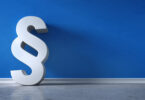 Paragraphen-Symbol vor blauer Wand.