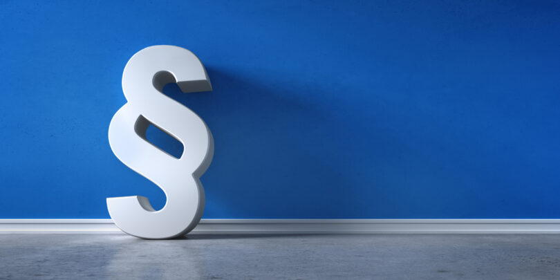 Paragraphen-Symbol vor blauer Wand.