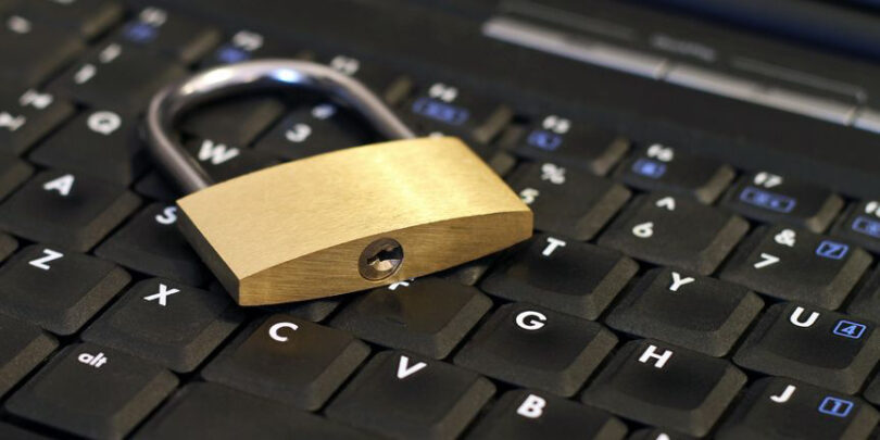 Nahaufnahme von Vorhängeschloss auf Laptoptastatur.
