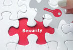 Close up of girl's hand placing the last jigsaw puzzle piece with word security and key icon as security concept.