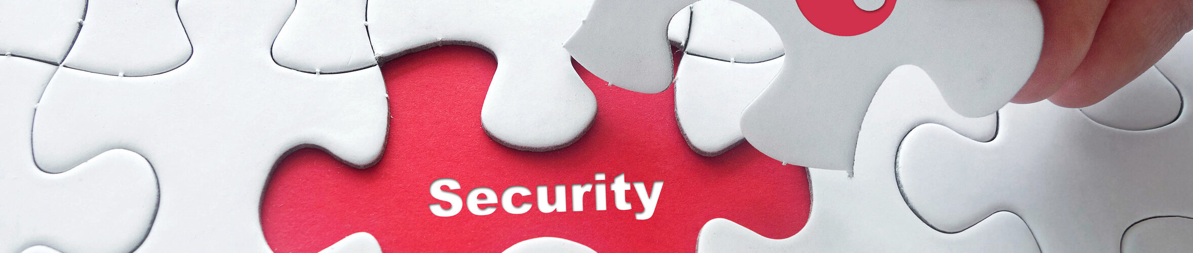 Close up of girl's hand placing the last jigsaw puzzle piece with word security and key icon as security concept.
