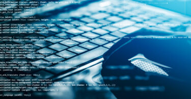 Hacker using laptop. Lots of digits on the computer screen.