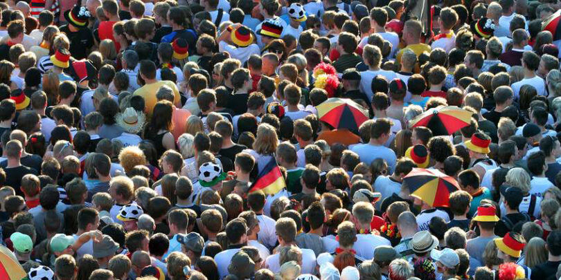Aufsicht einer dicht gedrängten Menge von Fußballfans.