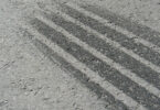 Nahaufnahme einer Bremsspur auf grauem Asphalt.