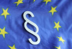 Paragrafenzeichen vor dem Hintergrund der Flagge der Europäischen Union.