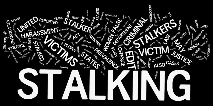 Wortwolke zum Thema Stalking in weißer Schrift auf schwarzem Grund.