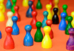 Ansammlung verschieden farbiger Mensch-ärgere-dich-nicht-Spielfiguren.