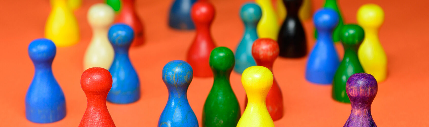 Ansammlung verschieden farbiger Mensch-ärgere-dich-nicht-Spielfiguren.