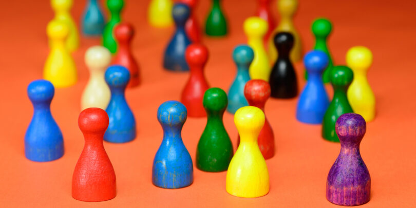 Ansammlung verschieden farbiger Mensch-ärgere-dich-nicht-Spielfiguren.