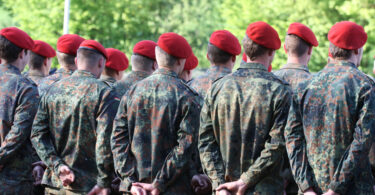 Bundeswehrsoldaten von hinten, in einer Reihe aufgestellt.