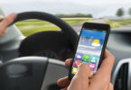 Close-up Of A Person's Hand Using Cellphone While Driving A Car.