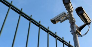 Detailansicht eines Sicherheitszaunes mit Überwachungskamera.