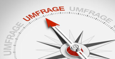 Kompass, dessen Nadel auf das Wort Umfrage zeigt.