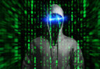 Virtueller Raum, aus dem sich eine bedrohliche Gestalt herausbildet, deren Gesicht von einer Kapuze verschattet ist und die blau leuchtende Augen hat.