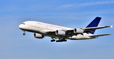 Im Landeanflug befindliches Passagierflugzeug vor blauem Himmel.
