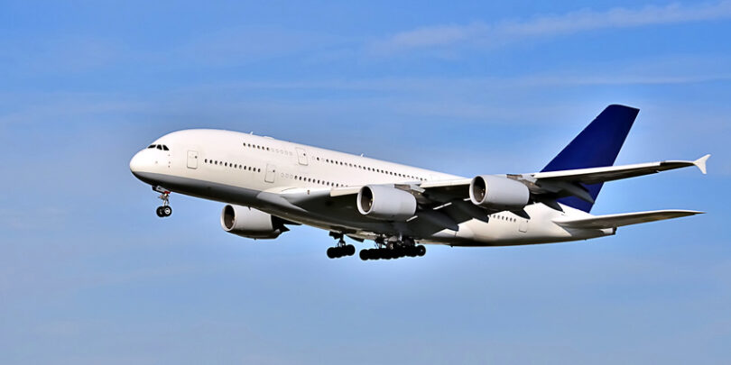 Im Landeanflug befindliches Passagierflugzeug vor blauem Himmel.