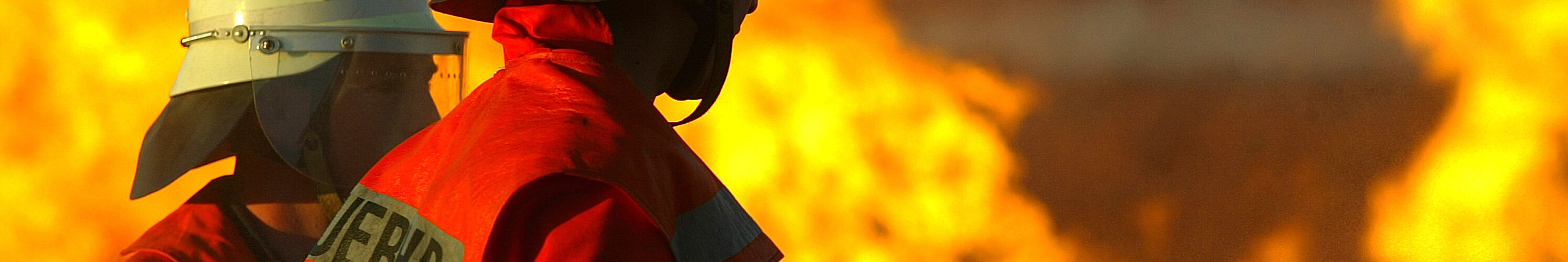 Zwei Feuerwehrmänner beim Löschen eines Brandes.
