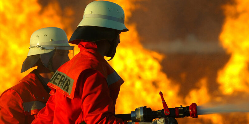 Zwei Feuerwehrmänner beim Löschen eines Brandes.
