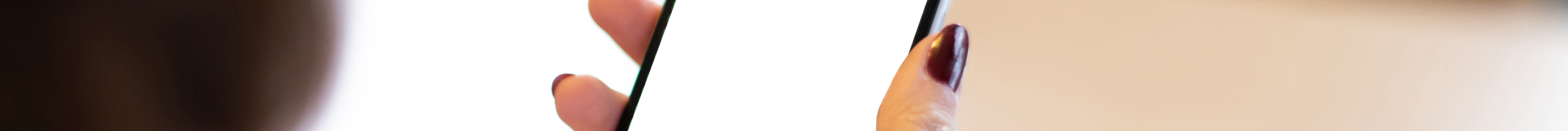 Smartphone mockup image of a woman's hand holding mobile phone with blank screen.