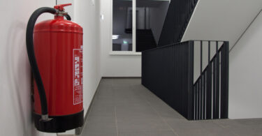 Feuerlöscher, der an der Wand eines Treppenhauses befestigt ist.