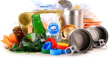 Recyclable garbage consisting of glass, plastic, metal and paper isolated on white background.