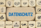 Übereinander gestapelte Würfel mit Symbolen, wobei auf dem mittleren Würfel "Datenschutz" steht.