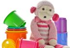 Ansammlung von Spielzeug, in deren Mitte sich ein Kuscheltieraffe befindet.