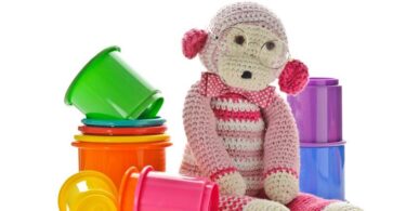 Ansammlung von Spielzeug, in deren Mitte sich ein Kuscheltieraffe befindet.
