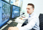 Security guard officer watching video monitoring surveillance security system.