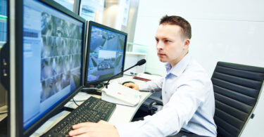 Security guard officer watching video monitoring surveillance security system.