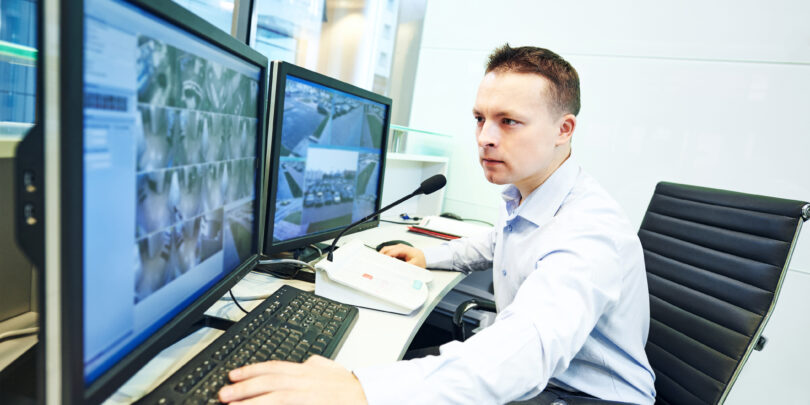 Security guard officer watching video monitoring surveillance security system.