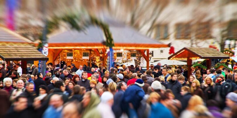 Menschenmasse auf Weihnachtsmarkt.