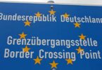Blaues Schild, das eine EU-Grenzübergangsstelle ausweist. Die Aufschrift lautet: "Bundesrepublik Deutschland. Grenzübergangsstelle. Border Crossing Point".