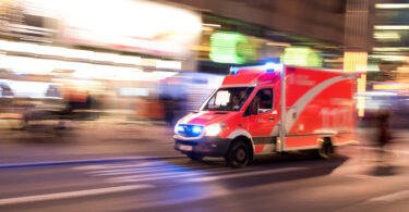 Rettungswagen der Berliner Feuerwehr fährt mit Blaulicht durch die Stadt.