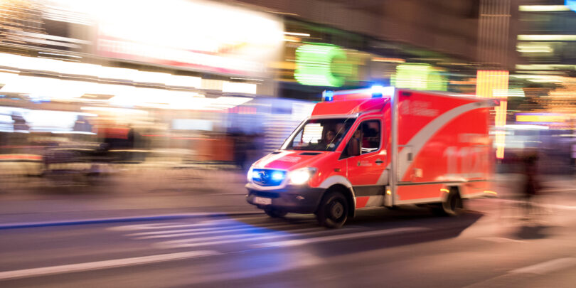 Rettungswagen der Berliner Feuerwehr fährt mit Blaulicht durch die Stadt.
