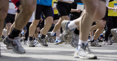 Beine mehrerer Teilnehmer an einem Marathonlauf.